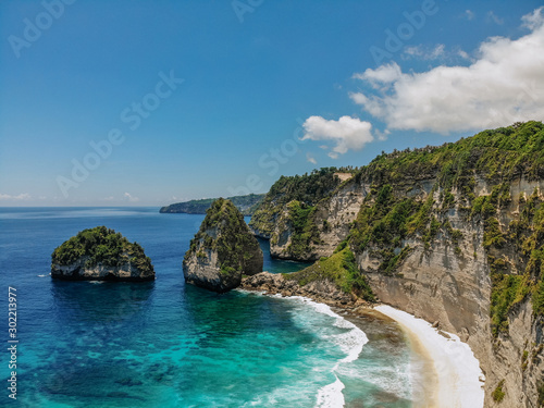 View of tropical beach, sea rocks and turquoise ocean, blue sky. Atuh beach, Nusa Penida island, Bali, Indonesia. Tropical background and travel concept