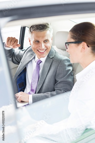 Business people discussing plans over document inside the car during business trip © moodboard