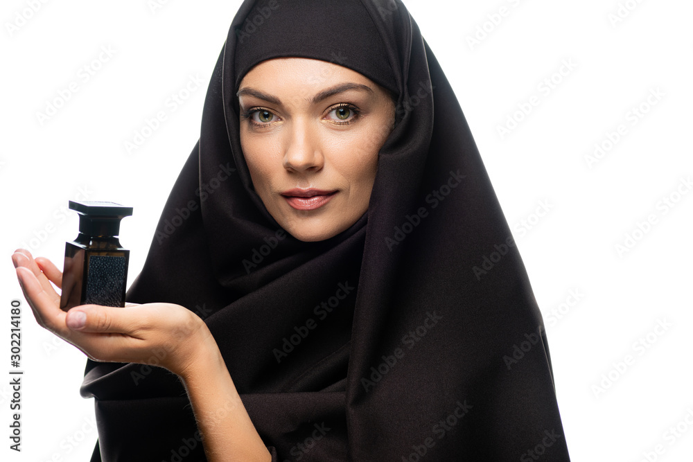young Muslim woman in hijab holding bottle of perfume isolated on white young Muslim woman in hijab holding bottle of perfume isolated on white