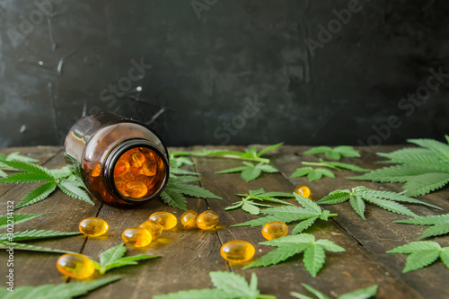 Medicinal CBD oil capsules and hemp leaves