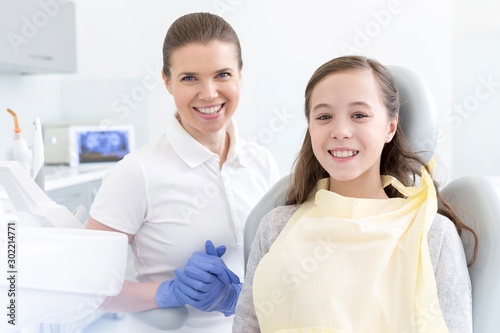 Smiling Dentist with child patient in clinic