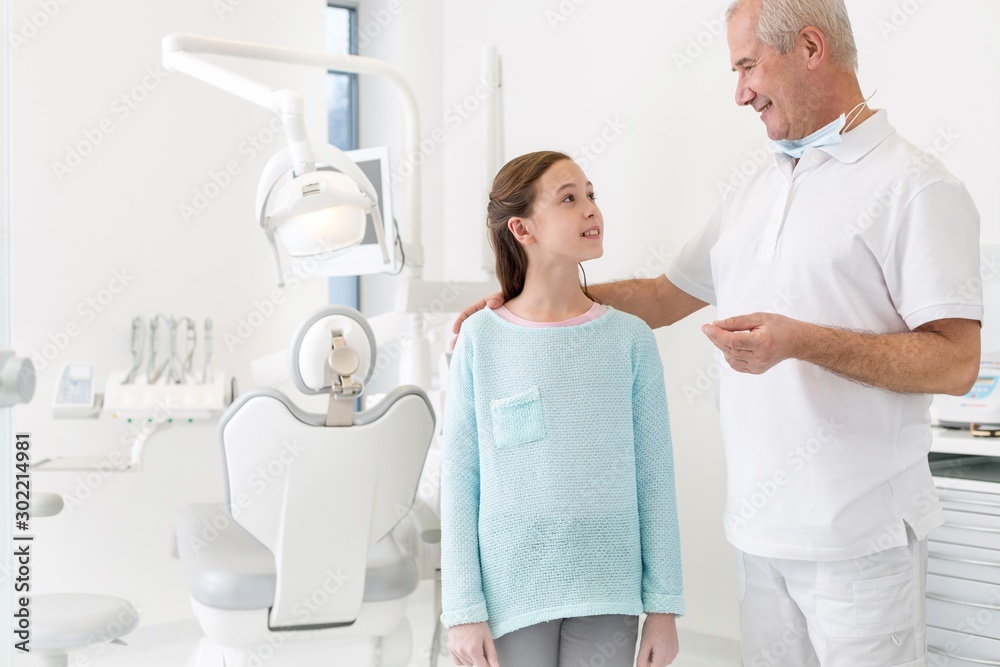 Dentist talking to child patient in clinic Dentist talking to child patient in clinic