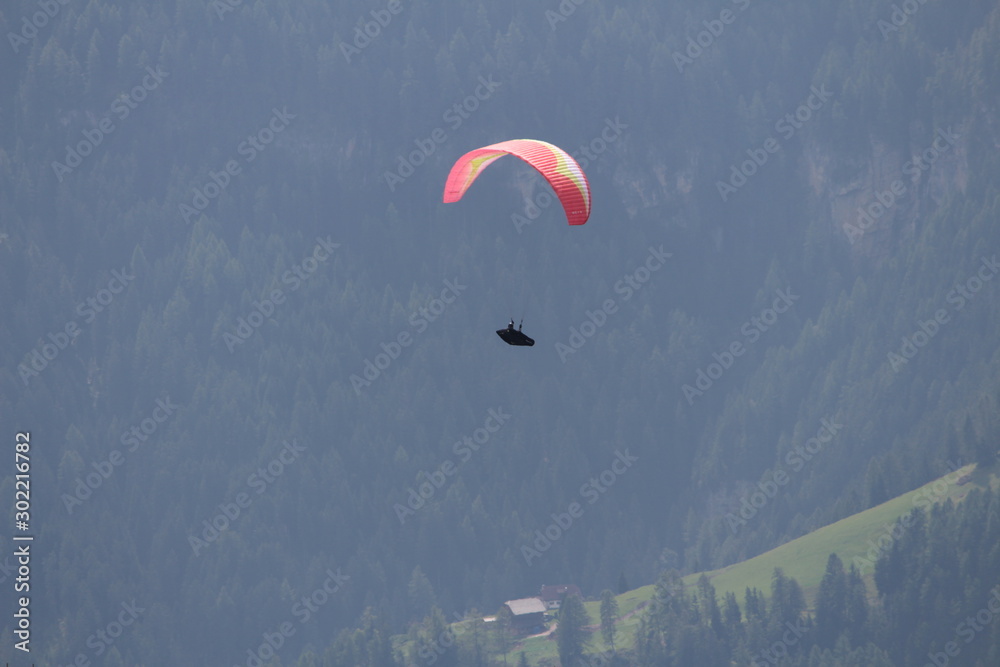 a man flies with a paraglider over the Alps of Trentino-Alto Adige a man flies with a paraglider over the Alps of Trentino-Alto Adige
