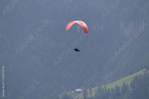 a man flies with a paraglider over the Alps of Trentino-Alto Adige