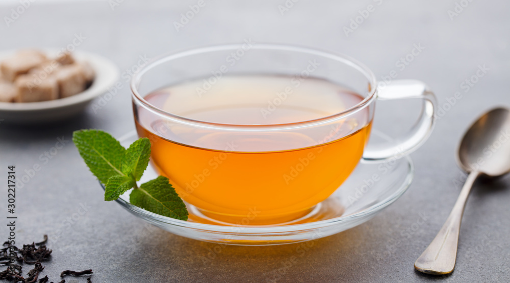 Tea cup with mint leaf. Grey background. Close up.