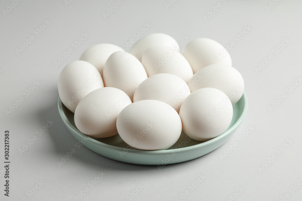 Chicken eggs in plate on gray background, space for text Chicken eggs in plate on gray background, space for text