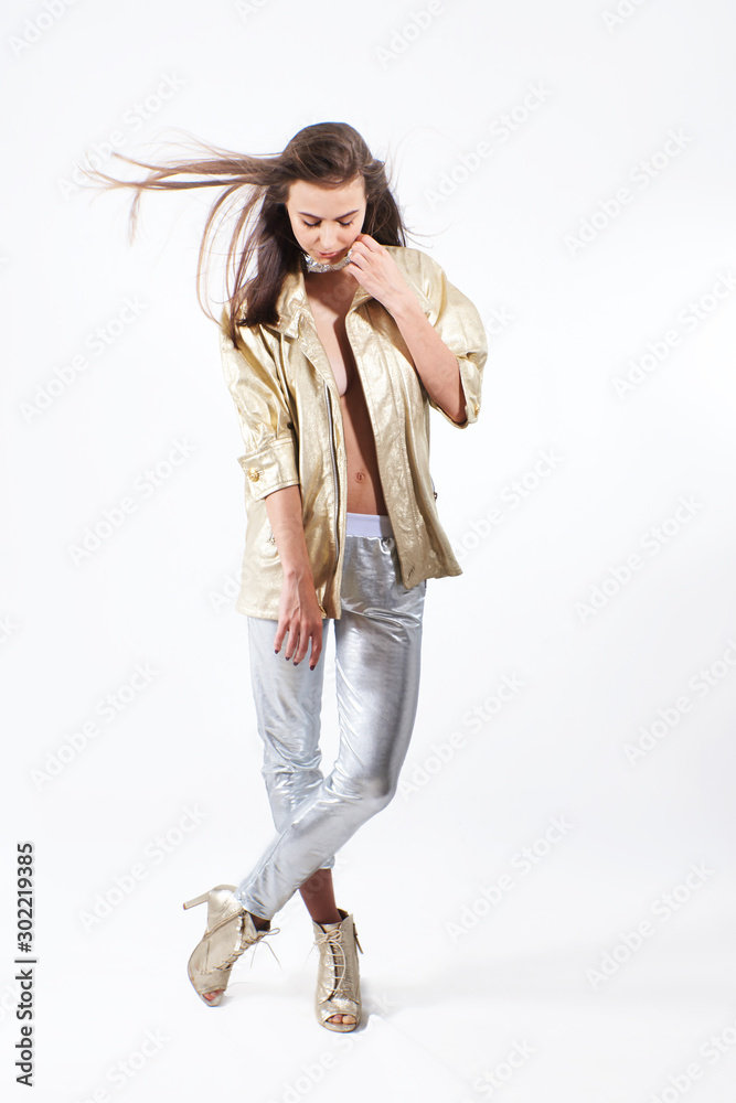 Young beautiful girl in a gold jacket and silver pants in the studio Young beautiful girl in a gold jacket and silver pants in the studio