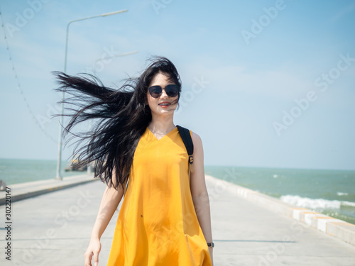 Asian woman with backpack have fun on the Hua Hin pier in sunny day. photo