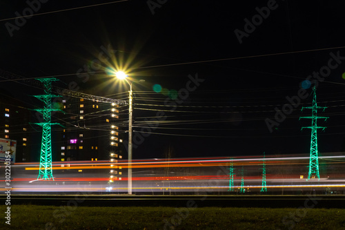 traffic in a night city past power lines photo