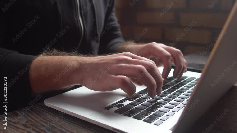 Man typing on laptop keyboard in the loft cafe. Close up man hands writing on laptop keyboard. Man typing on laptop keyboard in the loft cafe. Close up man hands writing on laptop keyboard.