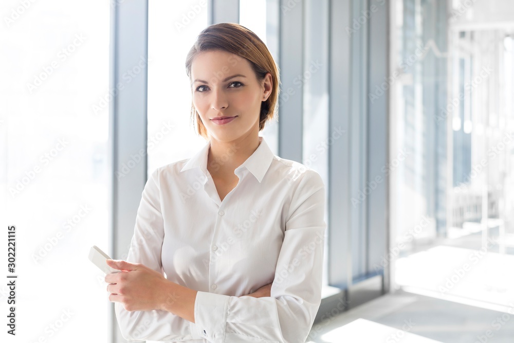 Businesswoman standing with arms crossed in office
