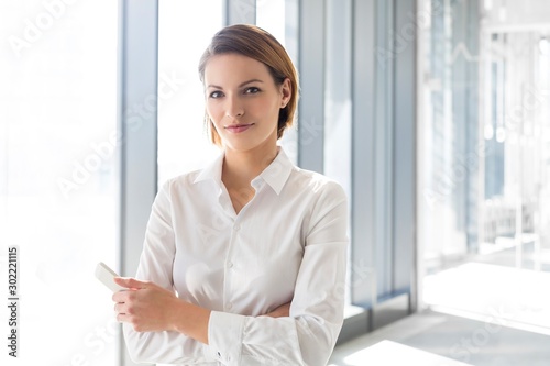 Businesswoman standing with arms crossed in office