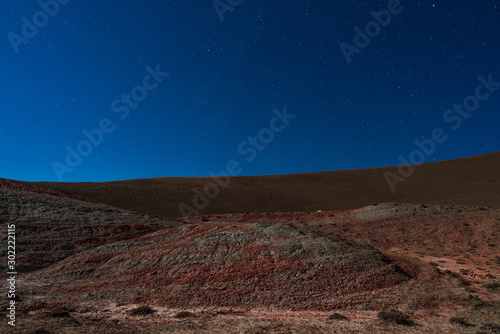 Amazing striped red mountains on a moon night