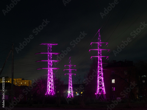 glowing towers of power lines at night