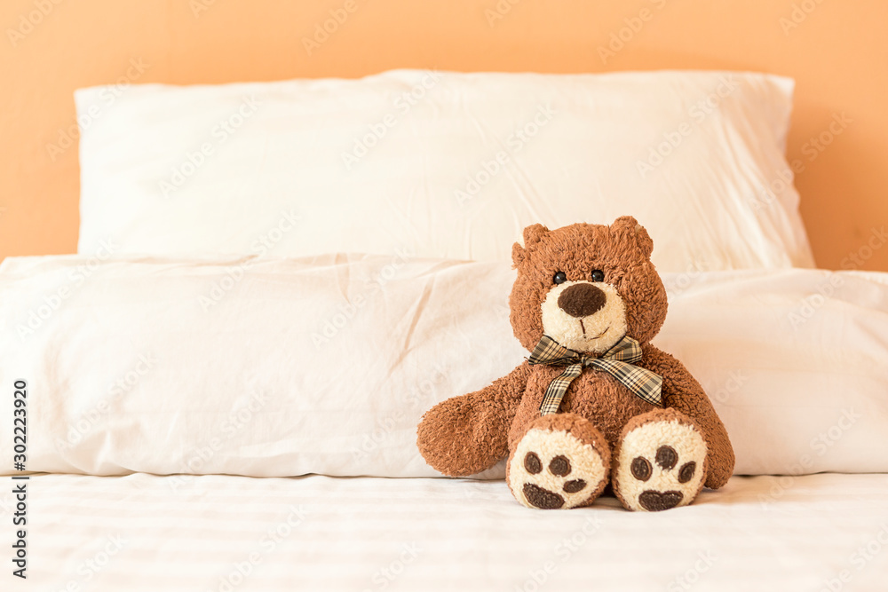 Brown teddy bear sitting alone on the bed, bed time