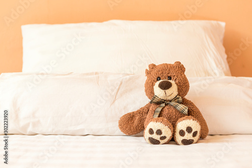 Brown teddy bear sitting alone on the bed, bed time