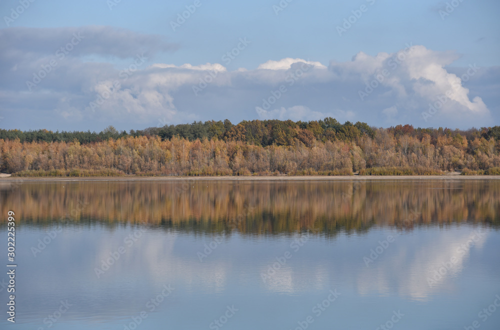 Autumn landscape with forest reflection on the lake in Poland.