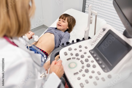 Doctor doing ultrasound on child patient abdomen in clinic