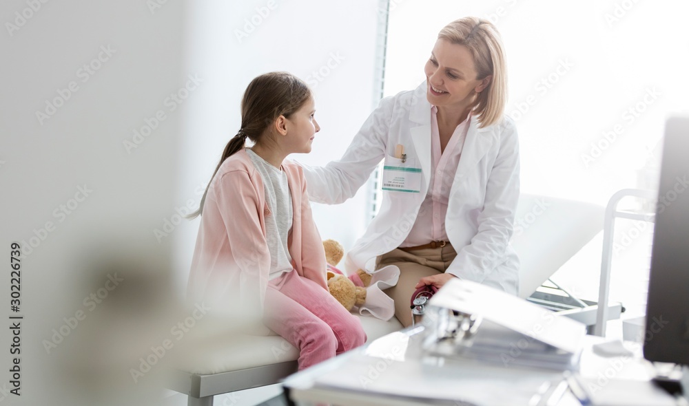 Doctor talking to child patient in clinic