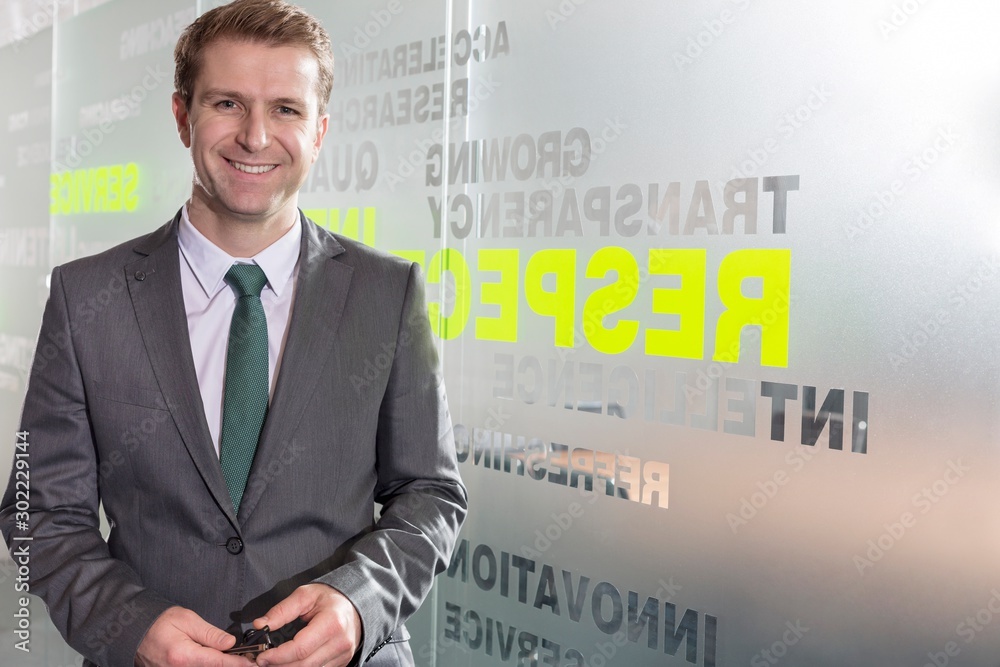 Smiling businessman standing in office Smiling businessman standing in office
