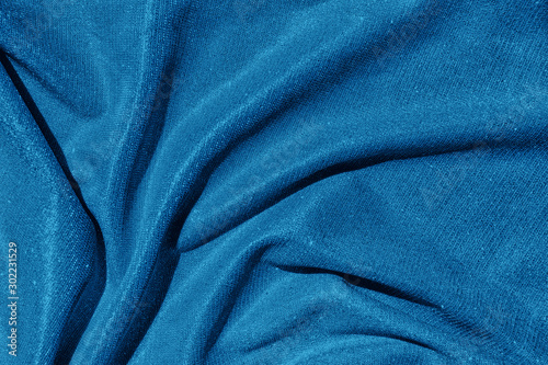 Dark blue colored Background of draped fabric with silver lurex thread. Beautiful fashionable fabric with a shiny thread for making clothes. Textile texture. Color trend concept.