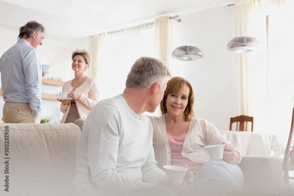 Mature couples talking in living room at home Mature couples talking in living room at home