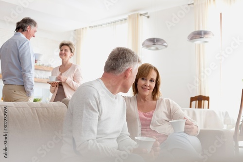 Mature couples talking in living room at home