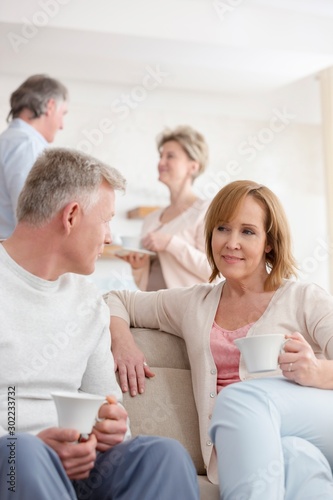 Mature couples talking in living room at home