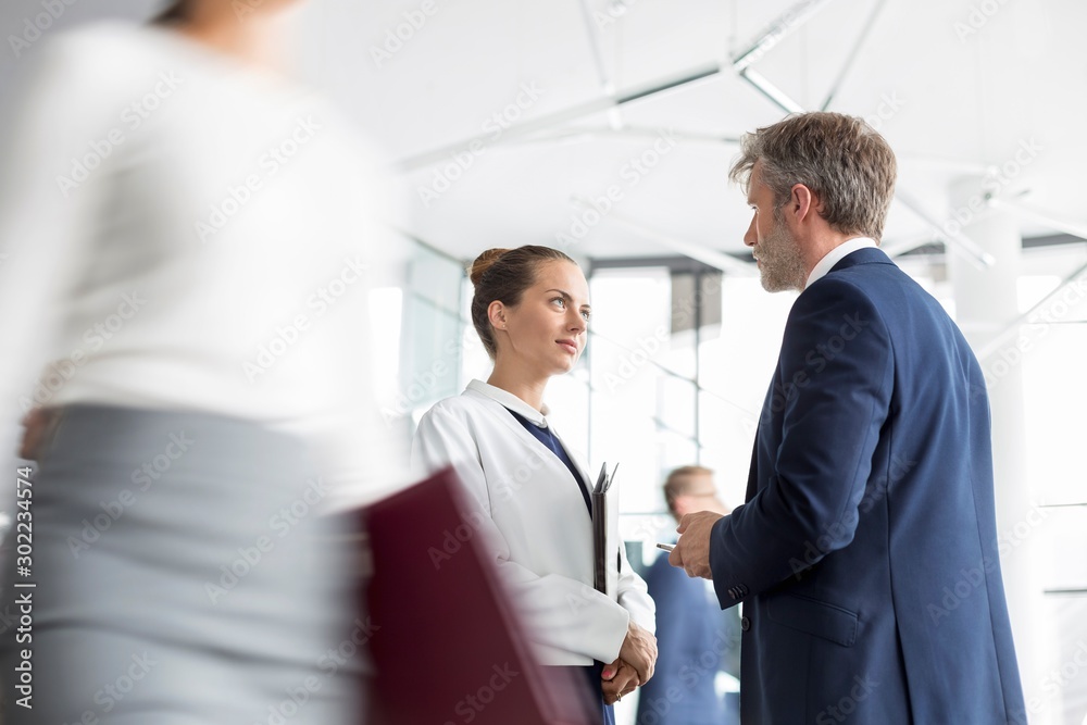 Mature male executive talking to his secretary in office Mature male executive talking to his secretary in office