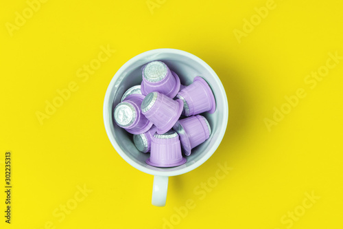 White Muf with Pink Coffee Capsules on Yellow Background Top View Horizontal Coffe Concept photo