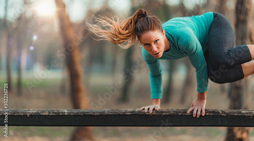 Canvas Print Woman Jumping Over the Wooden Huddles