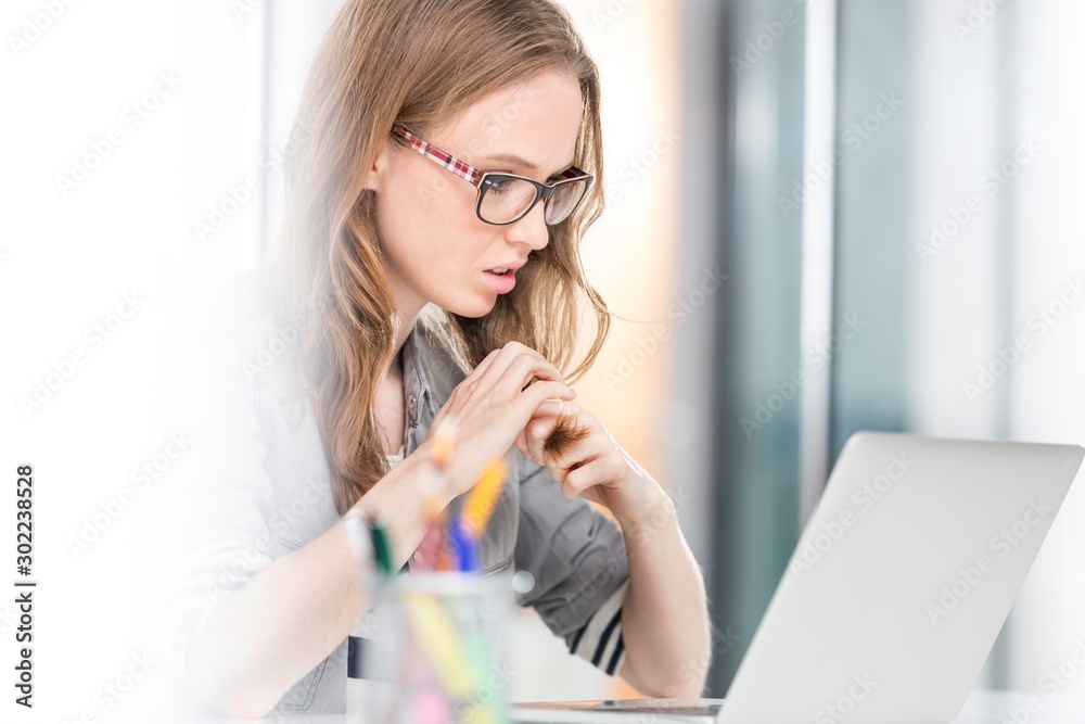 Stressed businesswoman sitting in her desk in office Stressed businesswoman sitting in her desk in office