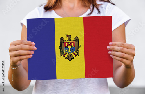 woman holds flag of Moldova on paper sheet