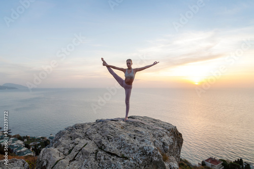 girl practices yoga at sunrise