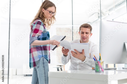 Secretary showing documents to businessman in office