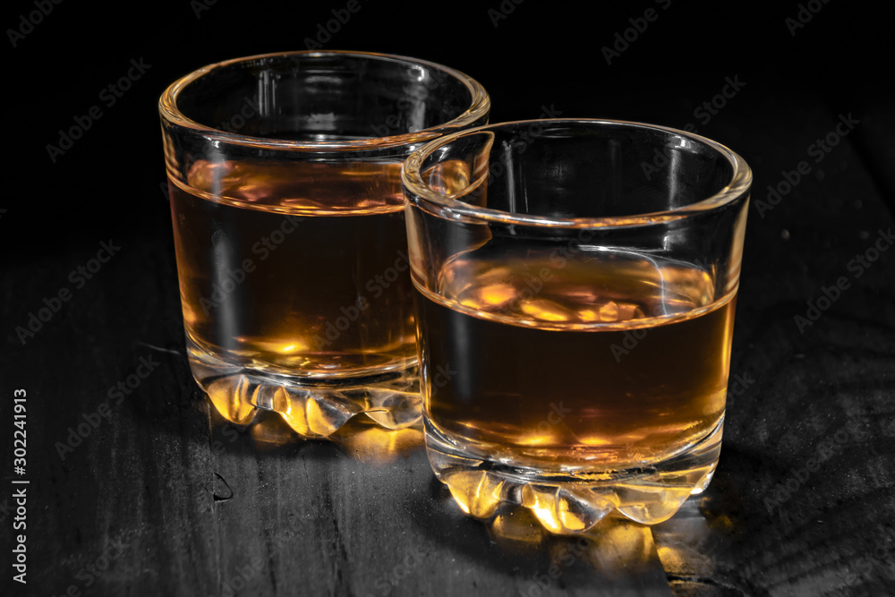 two glasses of cognac on a black tree two glasses of cognac on a black tree