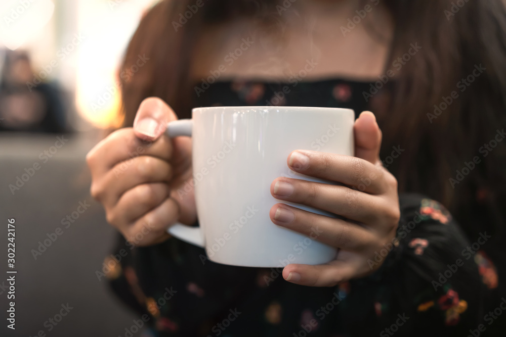 Close up of young girl holding white coffee mug with steam outdoors - Millennial woman drinking freshly brewed hot tea outside with winter sun - seasonal, beverage and lifestyle concept Close up of young girl holding white coffee mug with steam outdoors - Millennial woman drinking freshly brewed hot tea outside with winter sun - seasonal, beverage and lifestyle concept