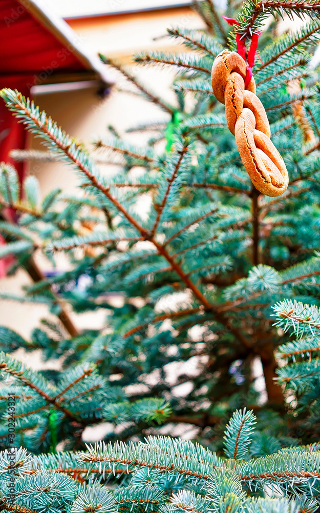 Part of the Christmas tree decorated with cookies pictured at the streets of old Riga in Latvia. It is considered that the tradition of the Christmas tree originated in Latvia. Selective focus. Part of the Christmas tree decorated with cookies pictured at the streets of old Riga in Latvia. It is considered that the tradition of the Christmas tree originated in Latvia. Selective focus.