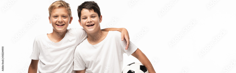 panoramic shot of happy boy hugging brother holding soccer ball isolated on white panoramic shot of happy boy hugging brother holding soccer ball isolated on white