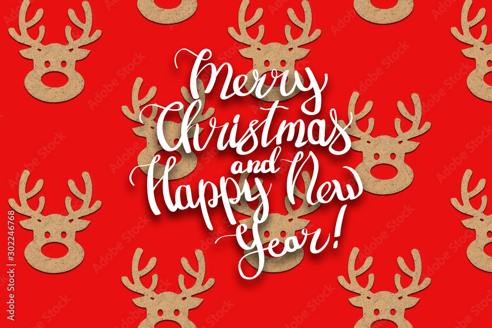 Wooden Christmas toys head of a deer is lined with a pattern on a red background. Add text Merry Christmas and Happy New Year. Minimalistic style. Flat lay, top view Wooden Christmas toys head of a deer is lined with a pattern on a red background. Add text Merry Christmas and Happy New Year. Minimalistic style. Flat lay, top view