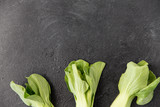 vegetable, food and culinary concept - close up of bok choy chinese cabbage on slate stone background