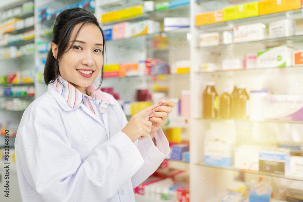 asian pharmacist standing in drugstore, they feeling happy and smile, pharmacist  female holding and looking drug strip pack with her hand