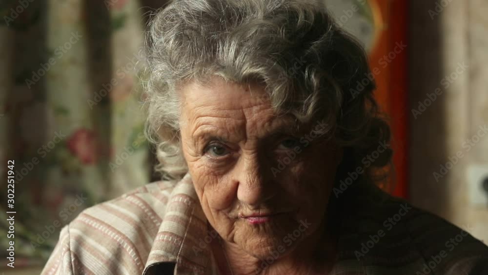 Elderly woman emotional face on a dark background slow motion Elderly woman emotional face on a dark background slow motion