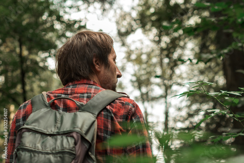 Man hiking in forest alone on active summer vacation
