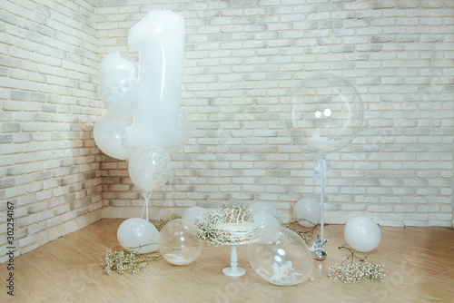 Festive background decoration for birthday with cake, white gypsophila flowers and white balloons in studio, girl Birthday .Cake Smash first year concept. photo