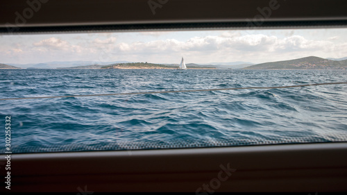 Das Mittelmeer mit Segelyacht und kroatische Küste durch ein Fenster unter Deck gesehen