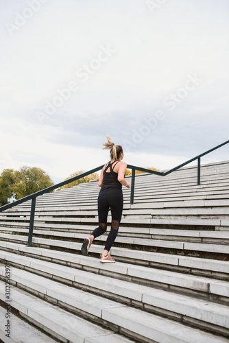 Fitness sport girl in fashion sportswear doing yoga fitness exercise in the street, outdoor sports, urban style