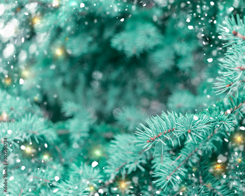 Christmas background with spruce branches, snowflakes, lights and sparks.