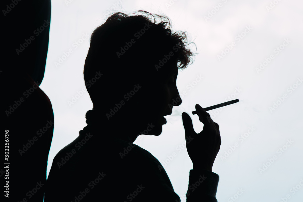 silhouette of man smoking cigarette