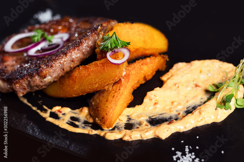 Grilled meat cutlets for burger on dark slate stone board.